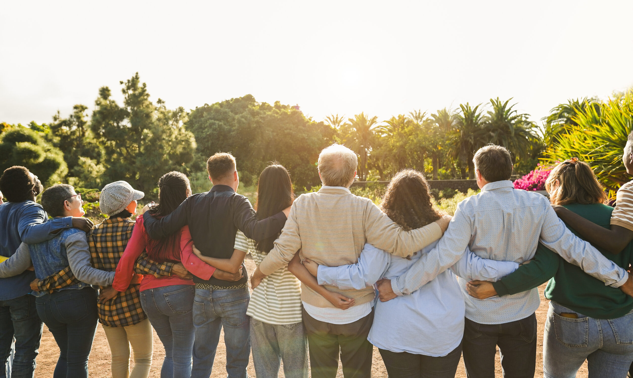 Group of multigenerational people hugging each others - Support, multiracial and diversity concept - Main focus on senior man with white hairs